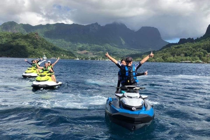 a man riding on the back of a boat in a body of water