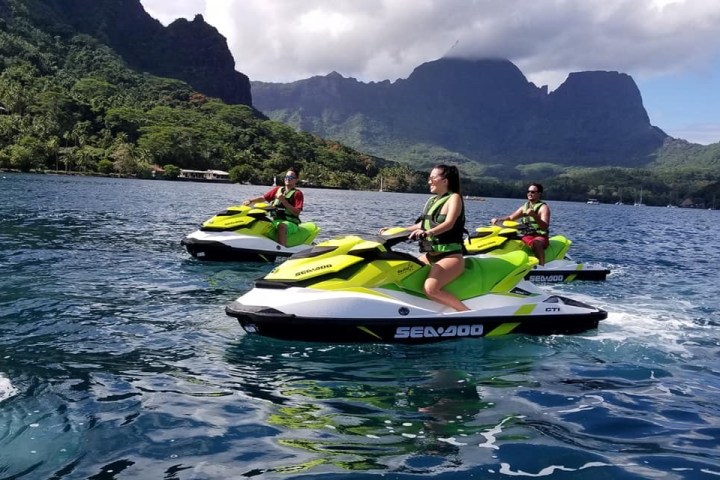 a group of people riding on the back of a boat in the water