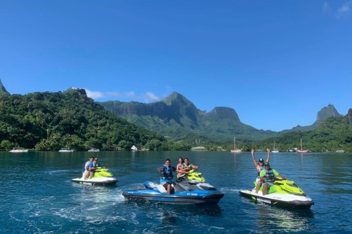 a group of people riding on the back of a boat in the water