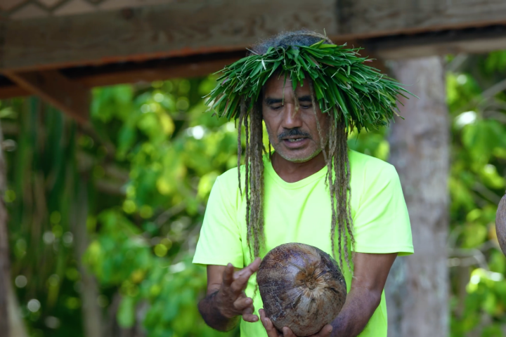 a man holding a banana tree
